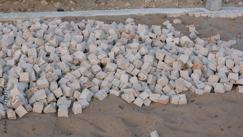 Stones in sand for construction of a Portuguese sidewalk / pavement in Portugal.