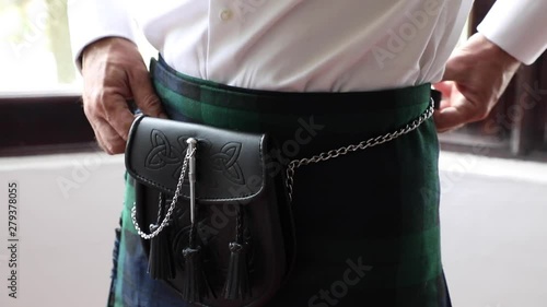 Man on Scottish kilt preparing