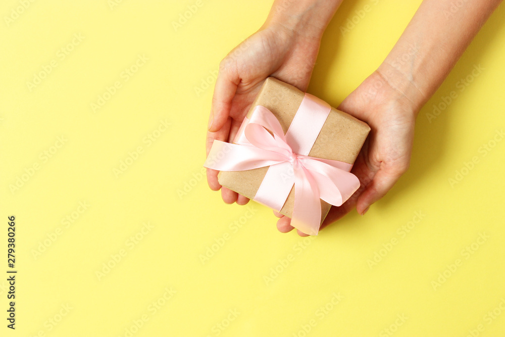 gift in female hands on a colored background top view. gift in female hands on a colored background top view.