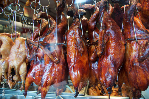 SAN FRANCISCO, CALIFORNIA, UNITED STATES - NOV 25th, 2018: Full body roast duck in city food market, Chinese restaurant, whole duck carcasses hanging on hooks while cooking in the oven