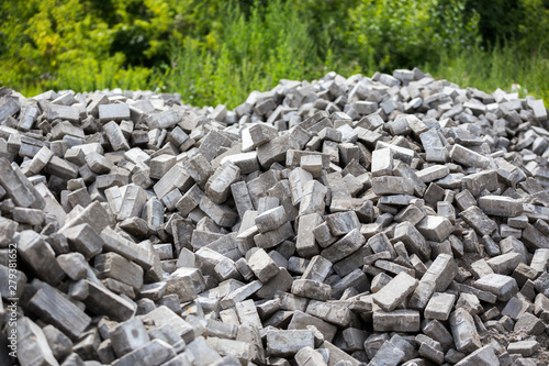 Pile of disassembled gray pavement bricks with selective focus photo