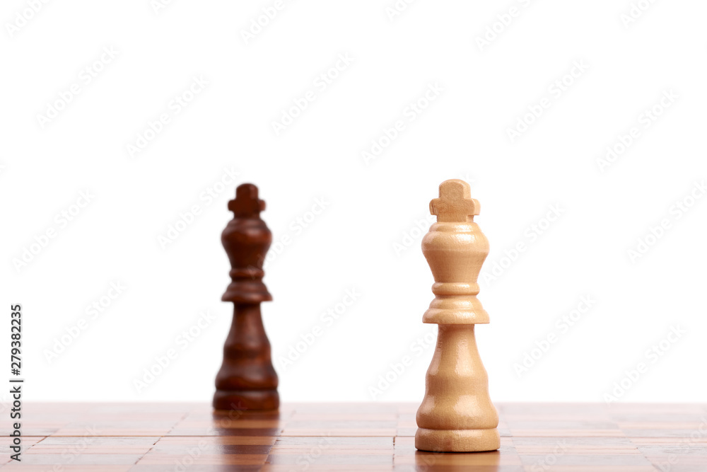 Two wooden chess pieces, black and white king on the board. Strategy, isolated on white background. Two wooden chess pieces, black and white king on the board. Strategy, isolated on white background.