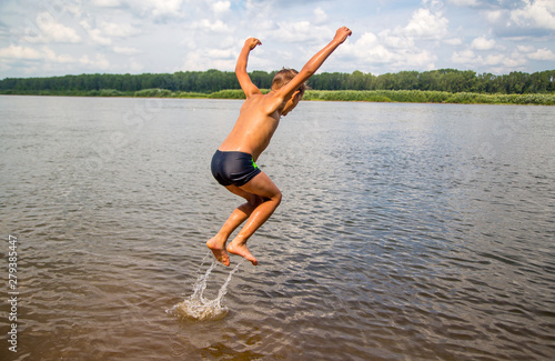happy boy jumps and flies over the water