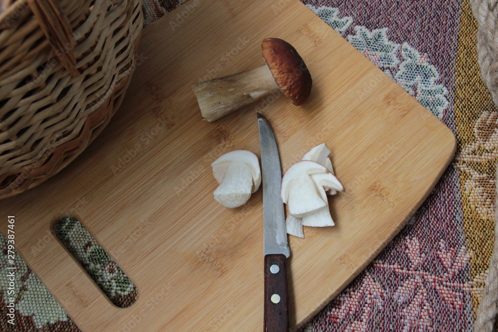 Cut slices of white mushroom with knife on wooden board Cut slices of white mushroom with knife on wooden board