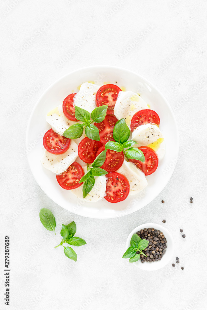 Fresh italian Caprese salad on white plate, view from above Fresh italian Caprese salad on white plate, view from above