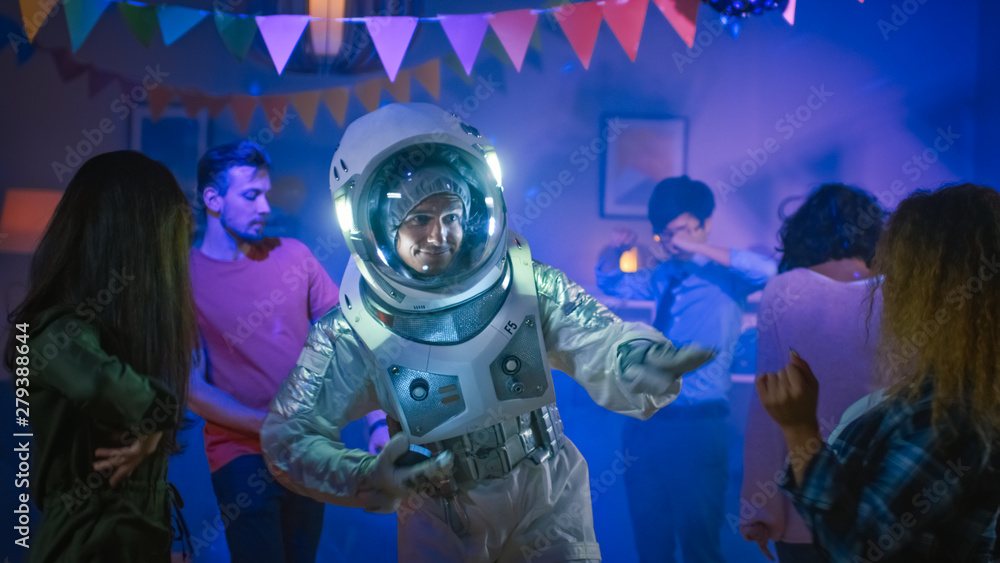 At the College House Costume Party: Fun Guy Wearing Space Suit Dances Off, Doing Robot Dance Modern Moves. With Him Beautiful Girls and Boys Dancing in Neon Lights. At the College House Costume Party: Fun Guy Wearing Space Suit Dances Off, Doing Robot Dance Modern Moves. With Him Beautiful Girls and Boys Dancing in Neon Lights.
