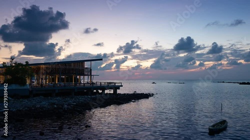 Night to day Times lapse of building turn off it light while sun rise and clouds move over the sea in the morning and a women get exercise in front of the sea, 4k timeslapse photo