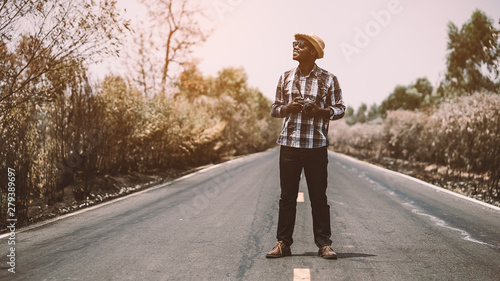 African man photographer traveling in countryside road. © arrowsmith2