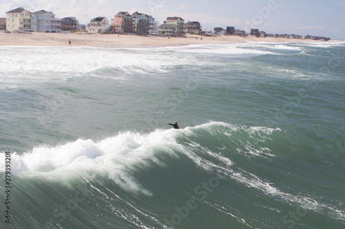 Surfing along pier with waves breaking
