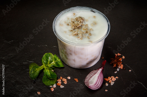 white lard in plastic bowl served with basil and onion slice