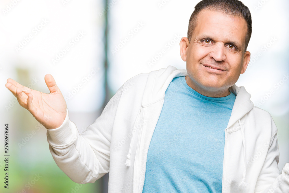 Middle age arab man wearing sweatshirt over isolated background clueless and confused expression with arms and hands raised. Doubt concept. Middle age arab man wearing sweatshirt over isolated background clueless and confused expression with arms and hands raised. Doubt concept.