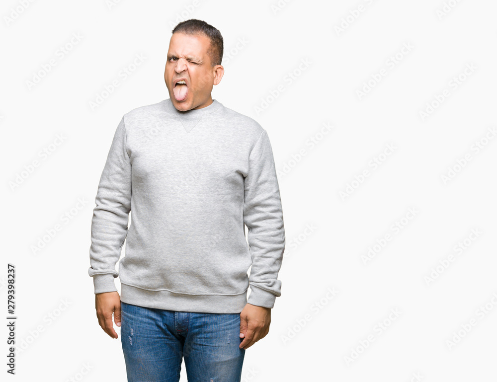 Middle age arab man wearing sport sweatshirt over isolated background sticking tongue out happy with funny expression. Emotion concept.