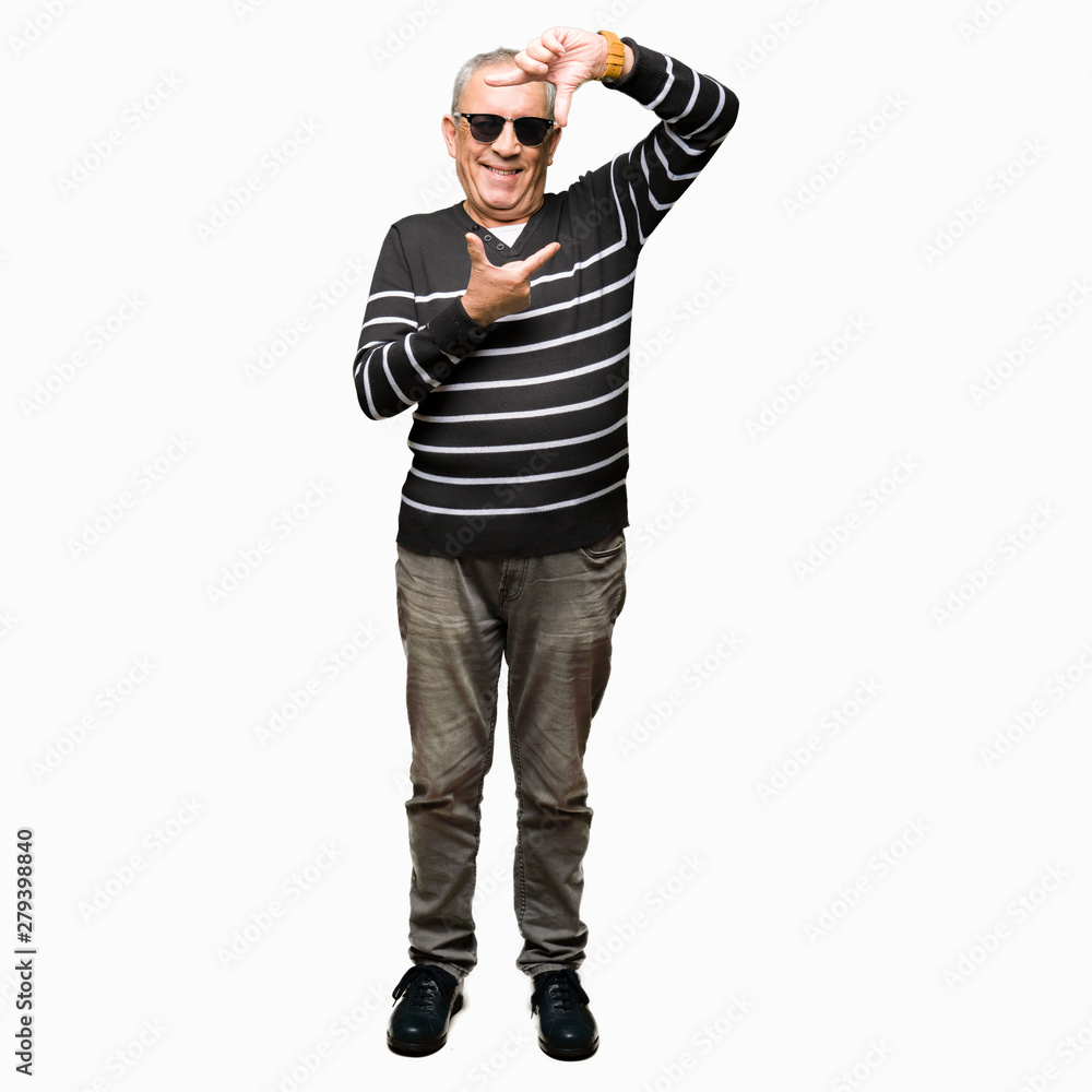 Handsome senior man wearing winter sweater and sunglasses smiling making frame with hands and fingers with happy face. Creativity and photography concept. Handsome senior man wearing winter sweater and sunglasses smiling making frame with hands and fingers with happy face. Creativity and photography concept.