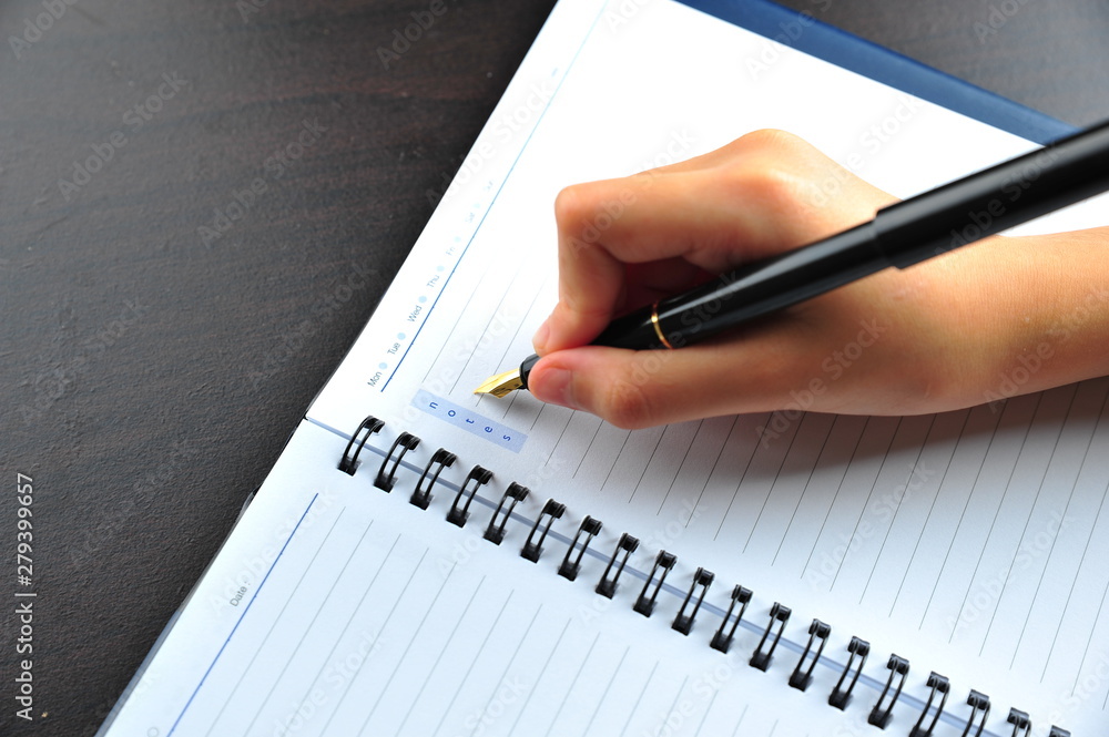 Hand Writing using Fountain Pen on a notebook