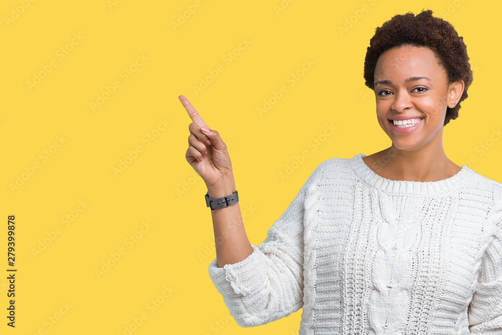 Beautiful young african american woman wearing sweater over isolated background with a big smile on face, pointing with hand and finger to the side looking at the camera. Beautiful young african american woman wearing sweater over isolated background with a big smile on face, pointing with hand and finger to the side looking at the camera.