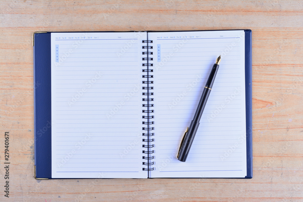 Notebook with fountain pen on wooden table Notebook with fountain pen on wooden table