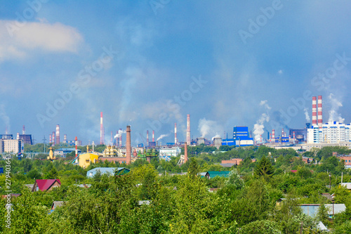 Heavy smoke industrial chimneys causing air pollution problems. Emissions are visible over residential areas of the city. Environmental pollution. Factory pipe, polluting the air.