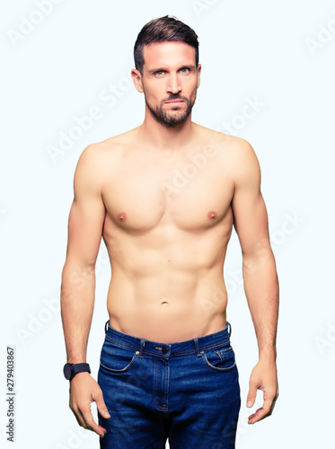 Handsome shirtless man showing nude chest skeptic and nervous, frowning upset because of problem. Negative person.