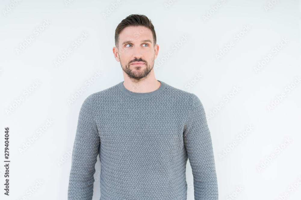 Young handsome man wearing casual sweater over isolated background smiling looking side and staring away thinking. Young handsome man wearing casual sweater over isolated background smiling looking side and staring away thinking.