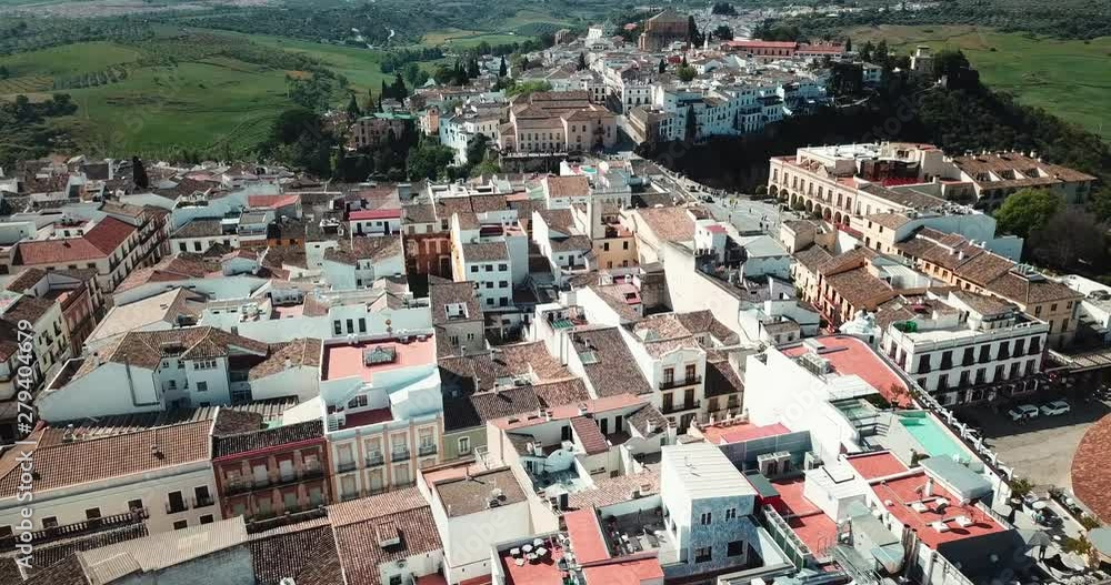 Aerial view of an ancient Spanish city Ronda in Andalucia. Drone flying over the famous bridge Puente Nuevo connecting the two parts of the Old Town, the Plaza de Toros Aerial view of an ancient Spanish city Ronda in Andalucia. Drone flying over the famous bridge Puente Nuevo connecting the two parts of the Old Town, the Plaza de Toros