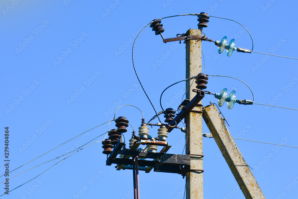 Pillar of electricity transmission line with transparent insulators. Photographed close-up. Against the blue sky Pillar of electricity transmission line with transparent insulators. Photographed close-up. Against the blue sky