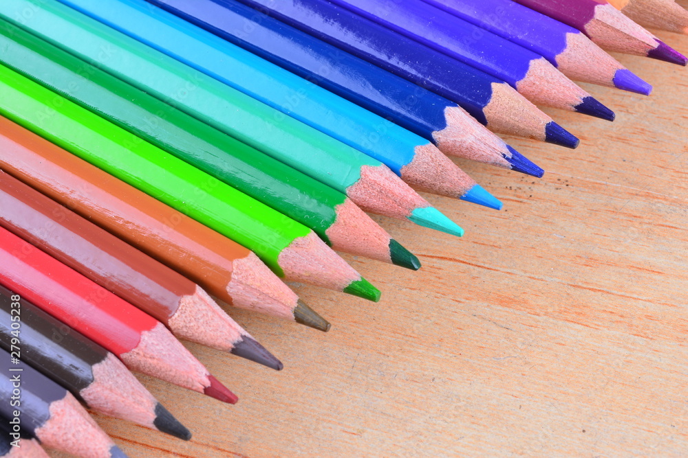 Close up stack colour pencils on wooden background Close up stack colour pencils on wooden background