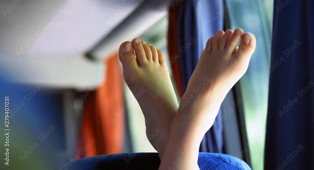 Fototapeta premium Relaxing. Woman putting up her bare feet on the back of a chair. Legs up