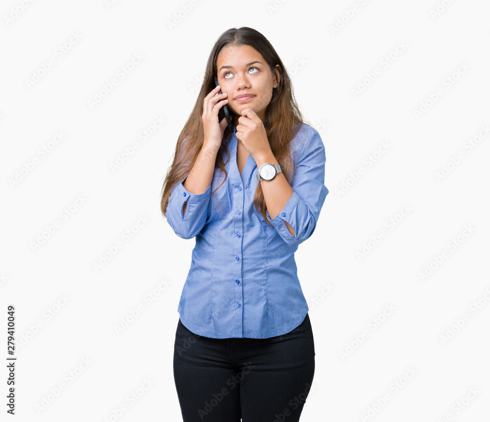 Young beautiful brunette business woman talking on smartphone over isolated background serious face thinking about question, very confused idea
