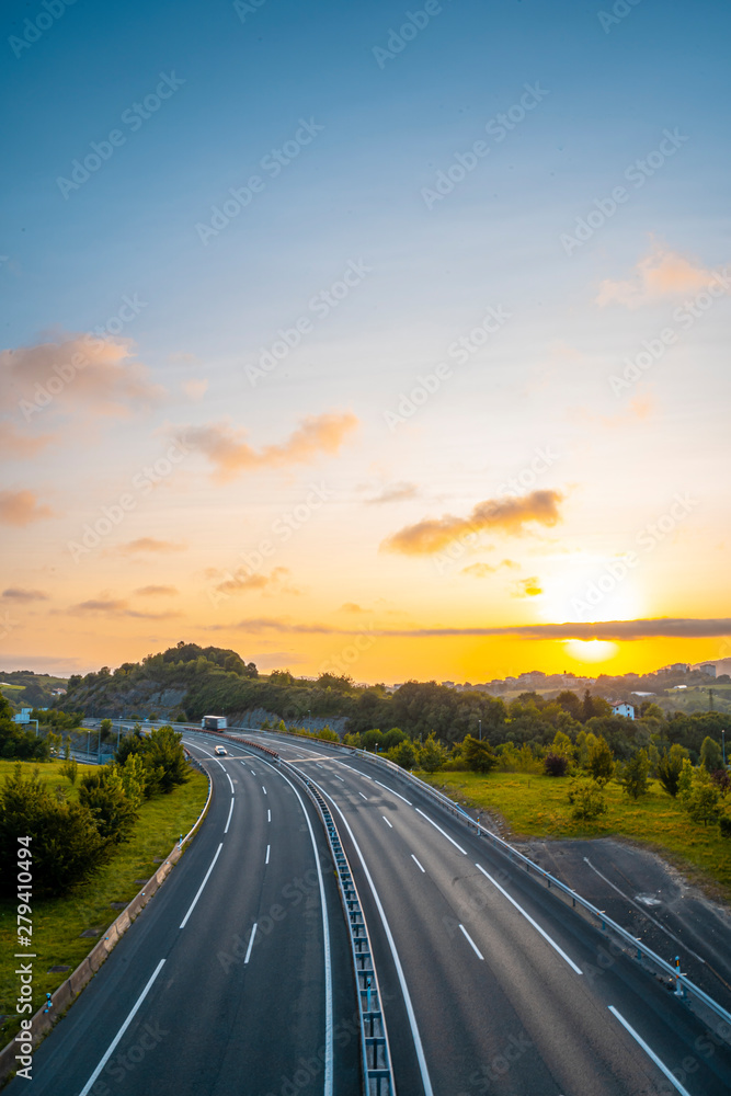 Sunset on a road, enter the clouds to cover the sun, vertical photo