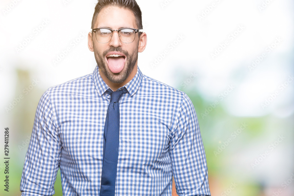 Young business man wearing glasses over isolated background sticking tongue out happy with funny expression. Emotion concept. Young business man wearing glasses over isolated background sticking tongue out happy with funny expression. Emotion concept.