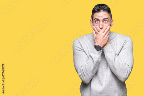 Young handsome man wearing sweatshirt over isolated background shocked covering mouth with hands for mistake. Secret concept.
