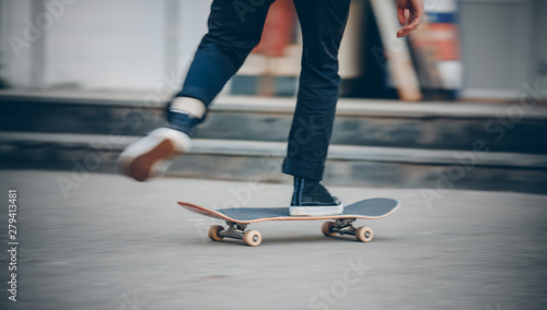 Skateboard man in shoes and jeans getting ready to jump kickflip olli from steps. Blurred background in motion photo