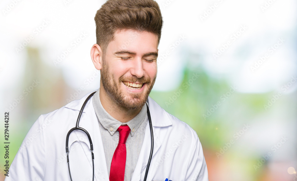Young handsome doctor man wearing medical coat Smiling and laughing hard out loud because funny crazy joke. Happy expression. Young handsome doctor man wearing medical coat Smiling and laughing hard out loud because funny crazy joke. Happy expression.