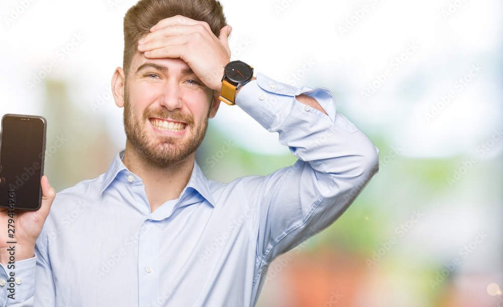 Young handsome man business showing smartphone screen stressed with hand on head, shocked with shame and surprise face, angry and frustrated. Fear and upset for mistake. Young handsome man business showing smartphone screen stressed with hand on head, shocked with shame and surprise face, angry and frustrated. Fear and upset for mistake.