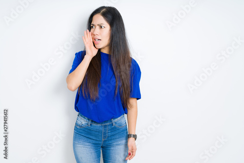 Beautiful brunette woman over isolated background shouting and screaming loud to side with hand on mouth. Communication concept.