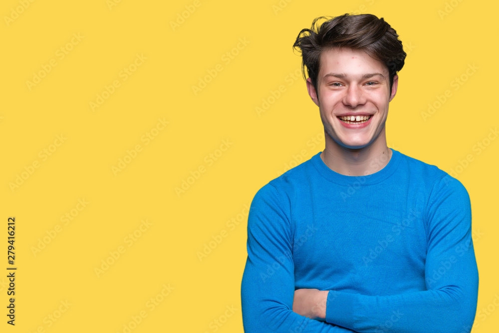 Young handsome man wearing blue sweater over isolated background happy face smiling with crossed arms looking at the camera. Positive person.
