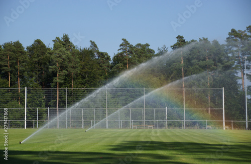 Rasensprenger auf dem Sportplatz erzeugen Regenbogen