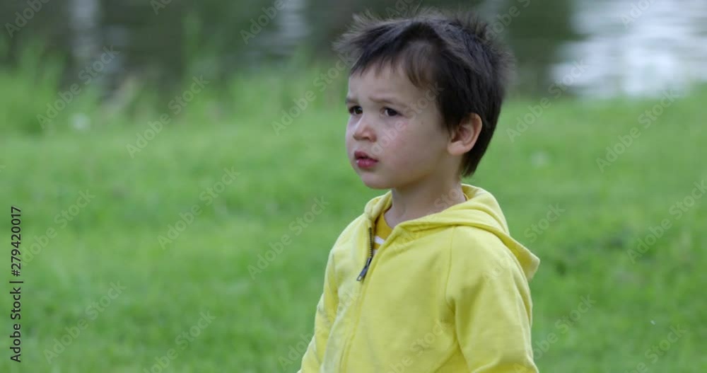 Toddler boy at park pointing towards water turns to look directly at camera - close up Toddler boy at park pointing towards water turns to look directly at camera - close up