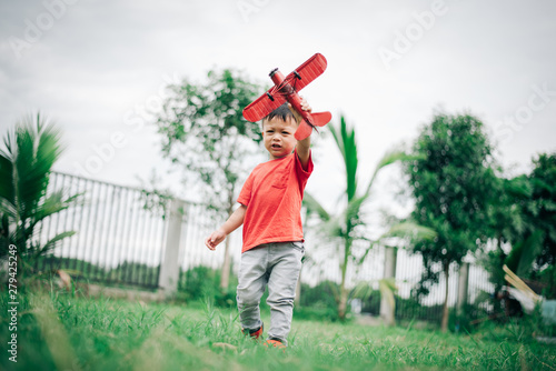 Boys are playing fun with toy planes At the garden in the house.Boys wearing red shirts photo