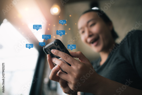 Happy smiling Asian woman holds mobile phone, close up focus on female hands and device. Customer buying goods via internet, friends chatting online, generation addicted with gadgets concept