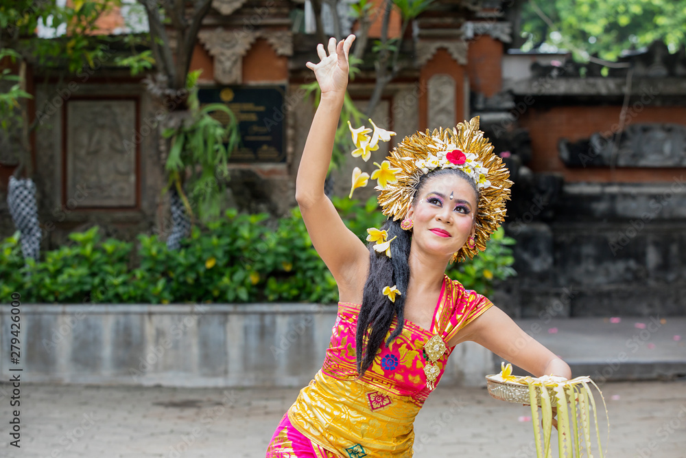 Beautiful Pendet dancer throws frangipani flowers