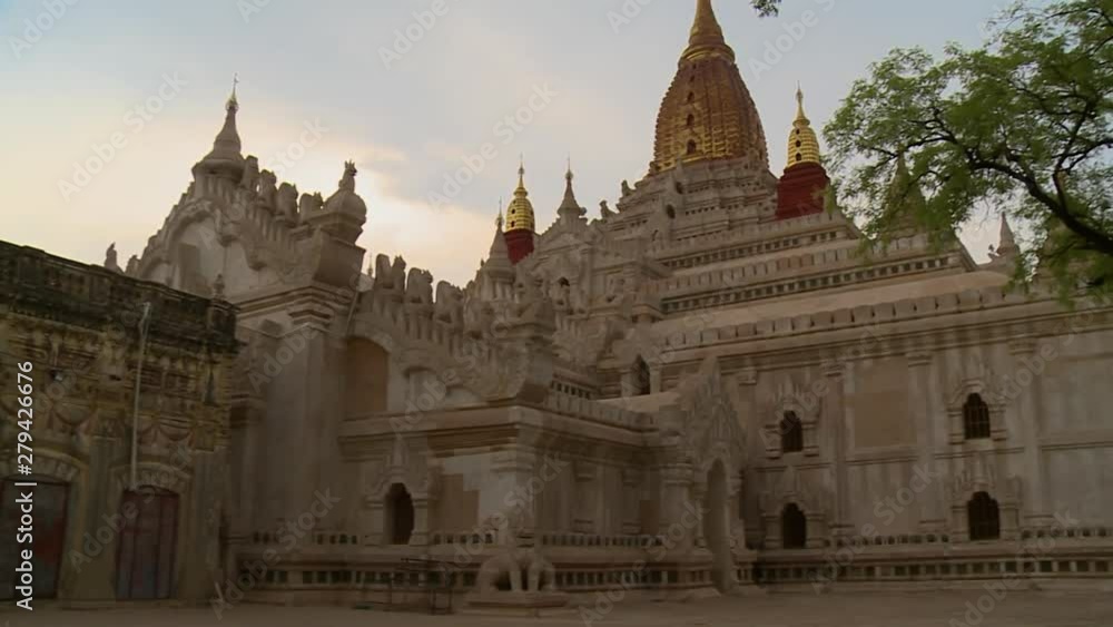 A low angle shot of a big white temple with golden stupas at top of the building in Burma A low angle shot of a big white temple with golden stupas at top of the building in Burma