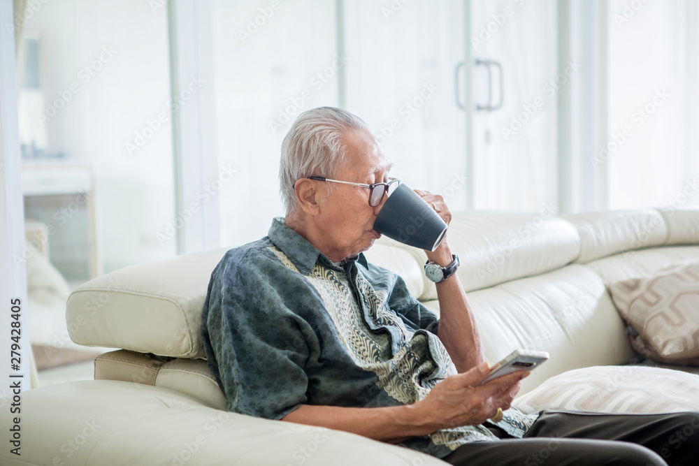 Senior man drinking hot tea on the couch Senior man drinking hot tea on the couch