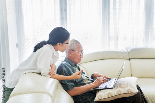 Senior man using laptop with his daughter
