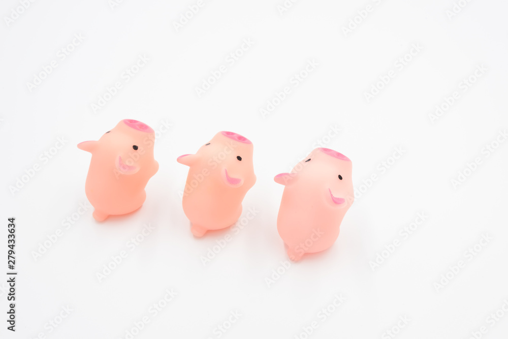 Three cute pink toy piglets neatly arranged standing on a white background Three cute pink toy piglets neatly arranged standing on a white background