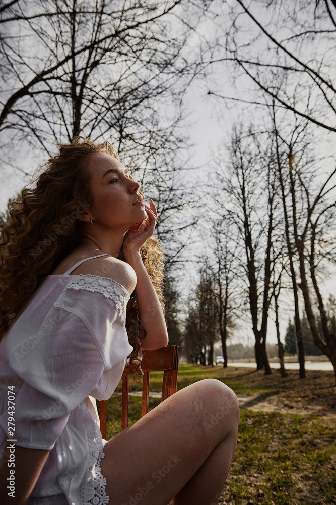 Naklejka premium Curly beautiful girl, portrait on the street, autumn yellow leaves.