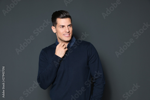 Portrait of handsome man smiling on grey background