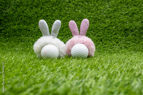 Golf Easter with rabbit ear on golf ball on green grass