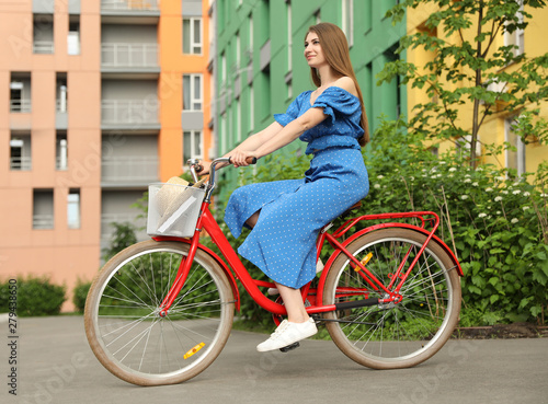 Young pretty woman riding bicycle in city
