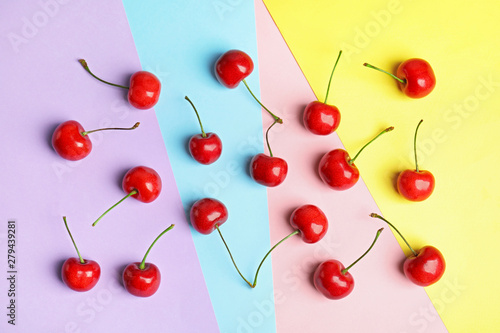 Flat lay composition with sweet cherries on color background